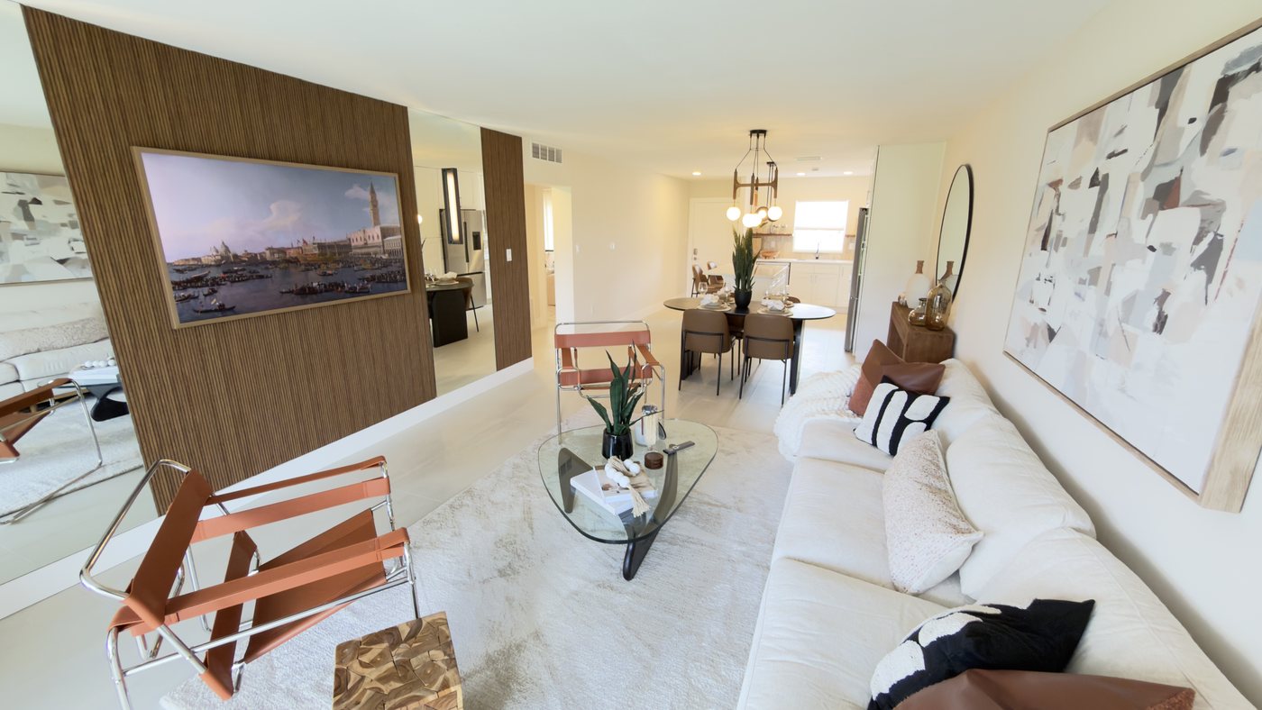 Renovated open living and dining area with a wood feature wall