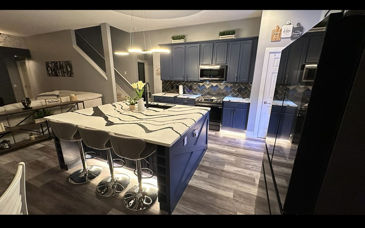 Kitchen remodel with navy cabinetry and a large center island