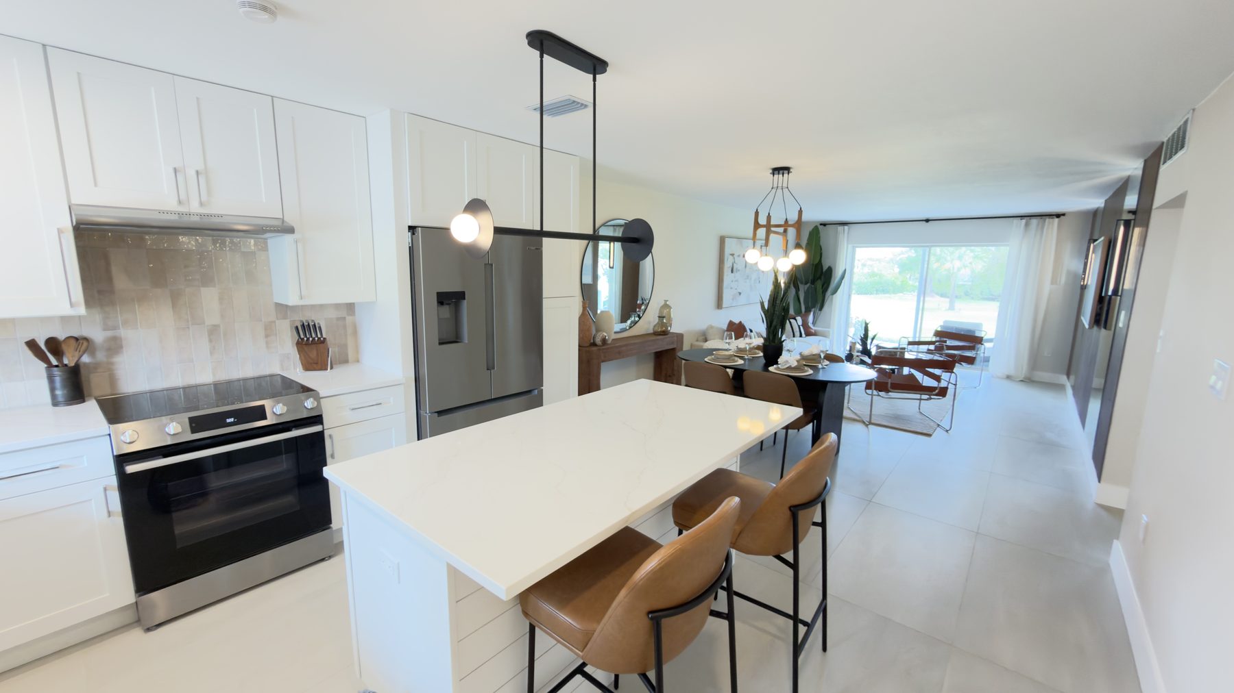 Renovated open kitchen with white cabinetry and a waterfall island in a Sarasota home
