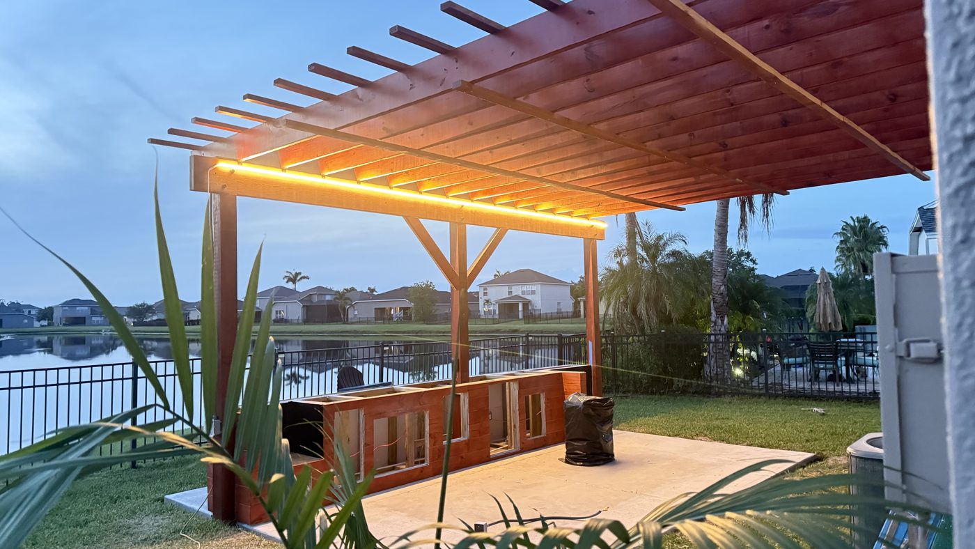 Custom covered pergola with integrated lighting over a waterfront deck